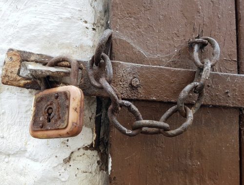 Stare drewniane drzwi zamknięte łańcuchem na kłódkę
