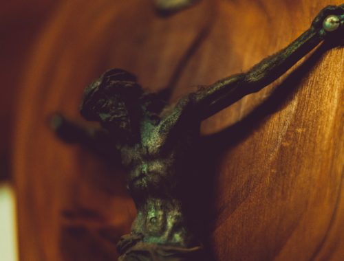 Metalowa figura Jezusa na drewnianej podporze